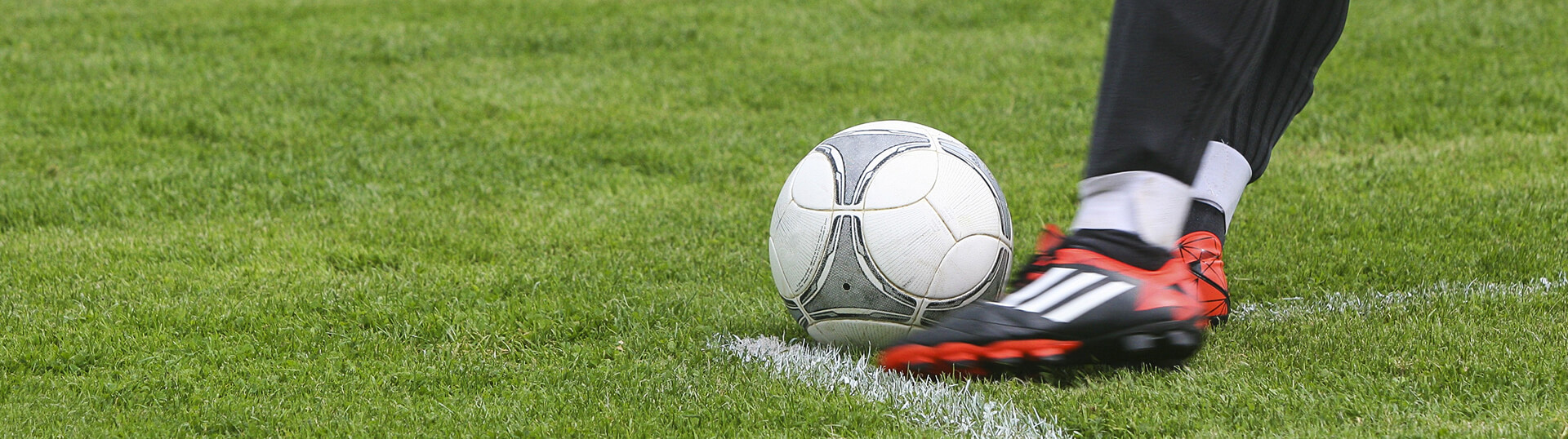 A close up of a foot kicking a soccer ball